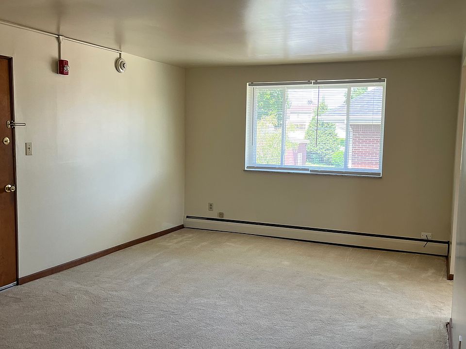 Living room with neutral carpeting and walls.