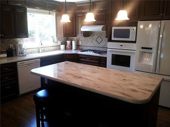 Updated kitchen features new counter tops and fixtures that comp