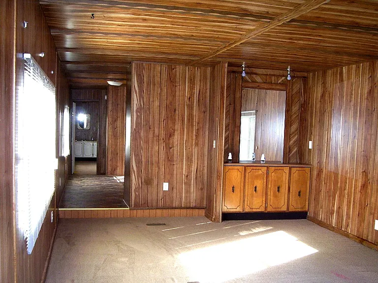 View from living room to kitchen on the left and cabinets with mirror on the right - window on either side