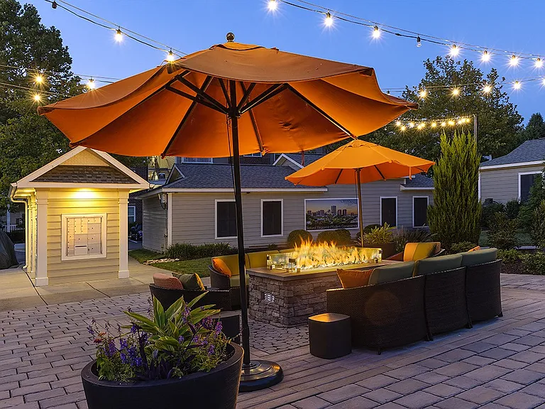 Outdoor lounge area with fire pit and cozy lighting