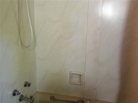 Main tub/shower is surrounded by corian.