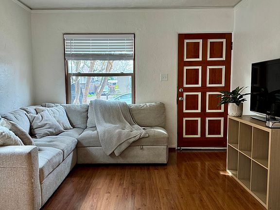 Open view from the kitchen into the cozy living room and front entry.