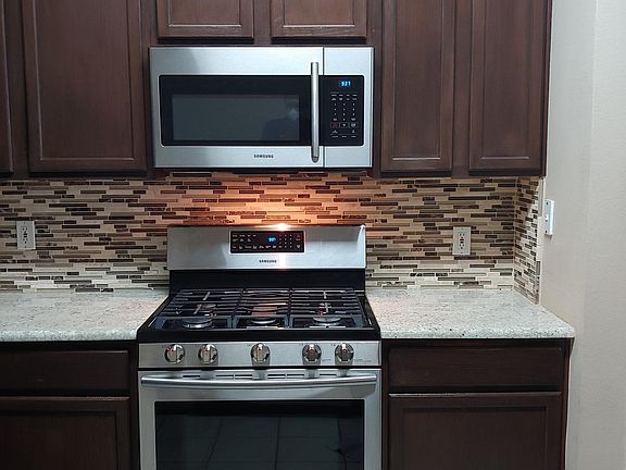 Kitchen with stainless steel Samsung appliances.