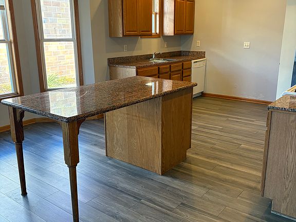 Kitchen with large island, stove/oven, dishwasher, and fridge