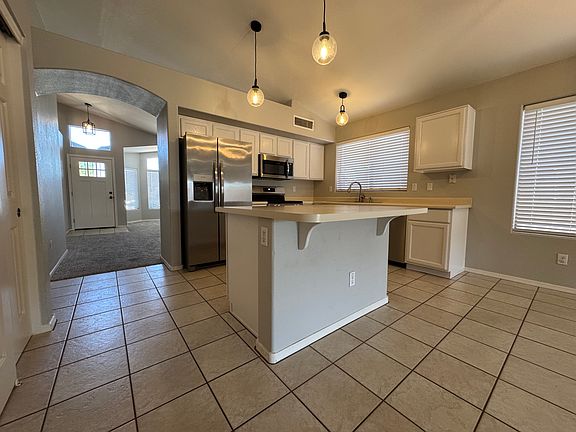 Kitchen includes: refrigerator, breakfast bar, built-in microwave, DW, disposer, farmhouse pendant lights and pantry