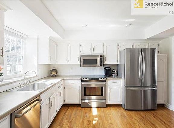 Enameled cabinets, stainless steel appliances and fresh paint enhance this sunny kitchen.