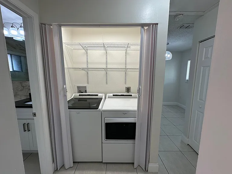 LAUNDRY AREA,
WITH ACCORDION DOORS OPEN.