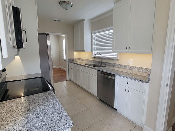 New kitchen renovation to include white shaker wood doors, soft close doors and drawers, pull-out trash bin, stainless steel appliances, cased window opening with new window blinds and matching granite sill to go with the Sienna white granite tops.