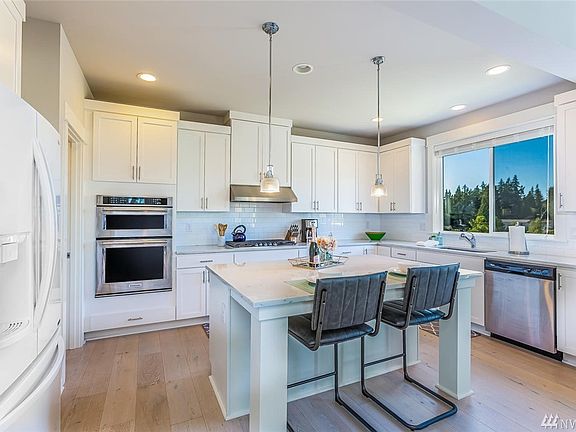 The kitchen is the heart of the home with bright and light surfaces that draw everyone to it.  Quartz slab counters with subway tile backsplash makes the space sparkle