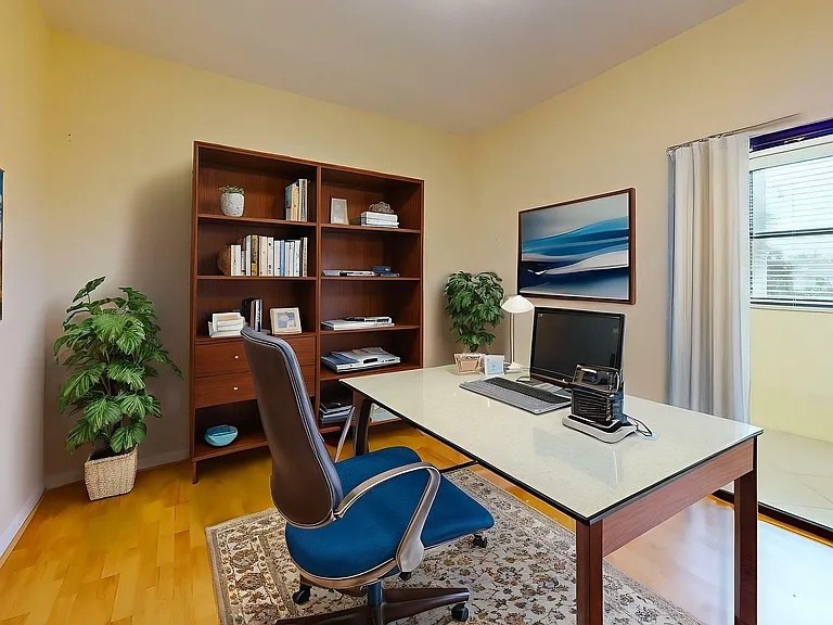 Inviting home office with elegant wooden shelves, a modern desk setup, stylish decor, and lush indoor plants.
