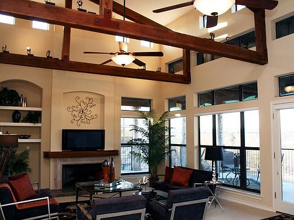 The living room soars accented by rustic beams bathed with light from the terrace and clearstory windows.