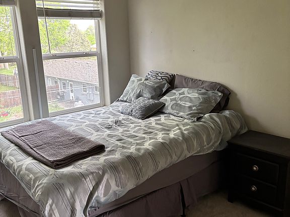 Furnished bedroom with hall bath next to it. Natural light looking out into the backyard.