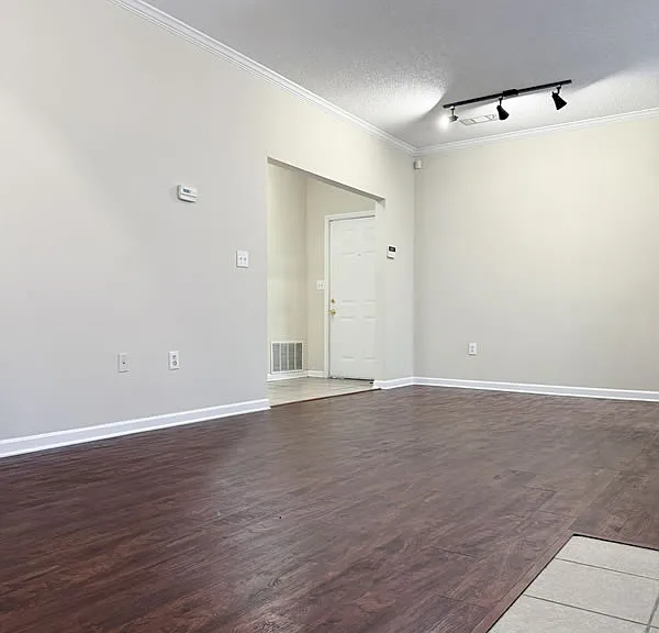 Great room with entrance foyer and track lighting over the dining area.