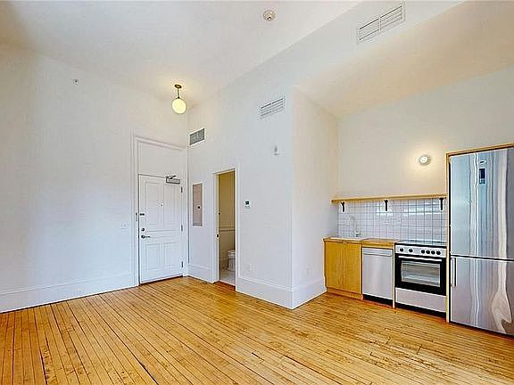 Main work/live space with soaring ceilings, natural light from oversized windows and hardwood floors.