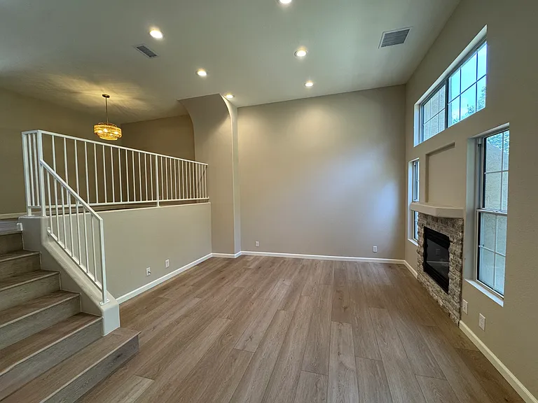 First level: Living Room with LED lighting, gas fireplace, direct access to two-car garage (not shown in photo)