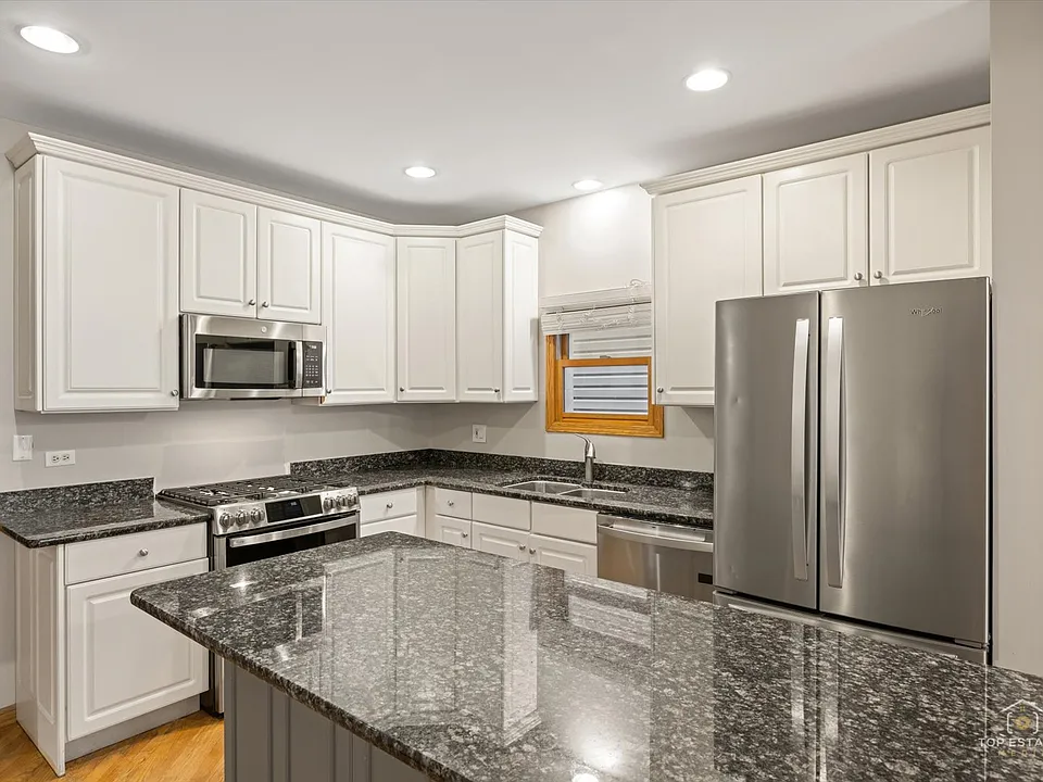 Kitchen with all the upgraded appliances including slide-in range with double oven and and griddle, extra large capacity fingerprint-resistant refrigerator and freezer, over-the-range microwave, dishwasher with stainless steel tub