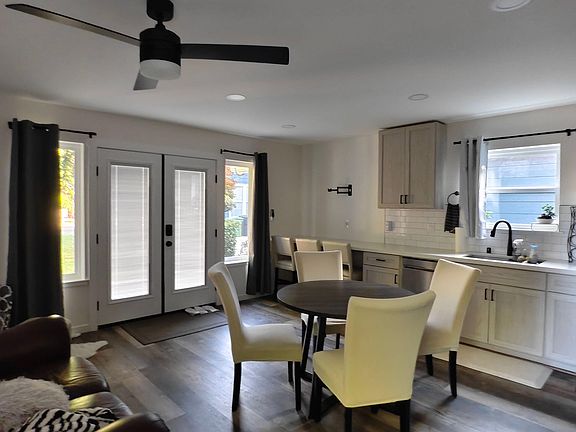 Open-concept kitchen and dining area with bar seating, ample cabinetry, and French doors leading outside.