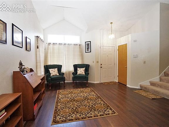 Living room has vaulted ceilings and wood flooring.