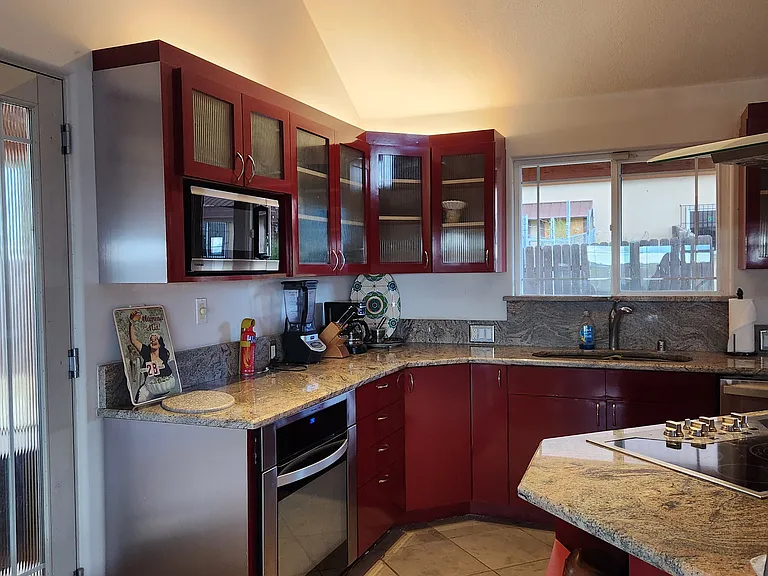 The kitchen from between the "fireplace" and the island which contains the stove, breakfast bar, and storage drawers and spaces.