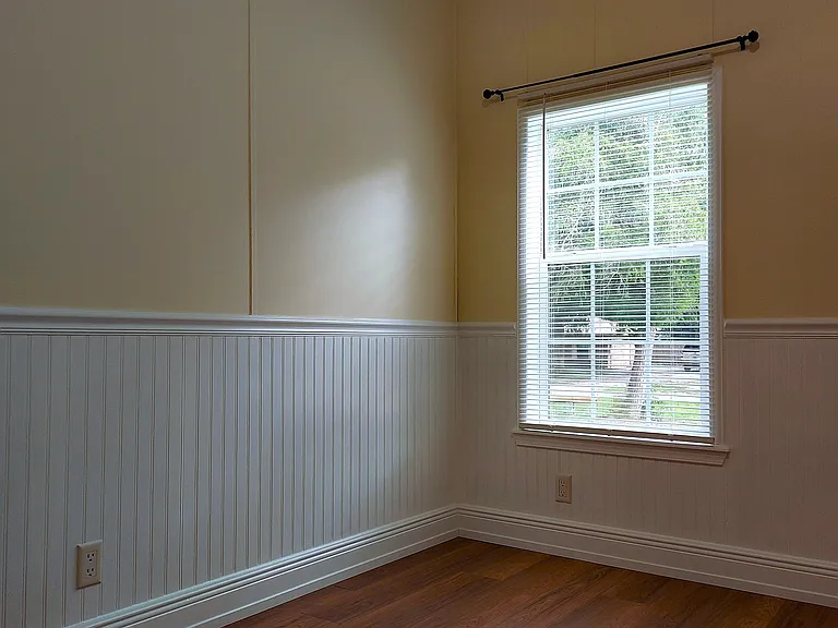 Fresh paint throughout the home, with white wainscoting, no-string blinds, and hung curtain rods.