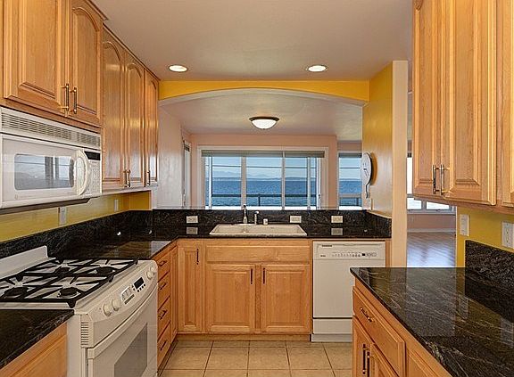 The kitchen has slab granite counters, lots of cabinets, gas coo