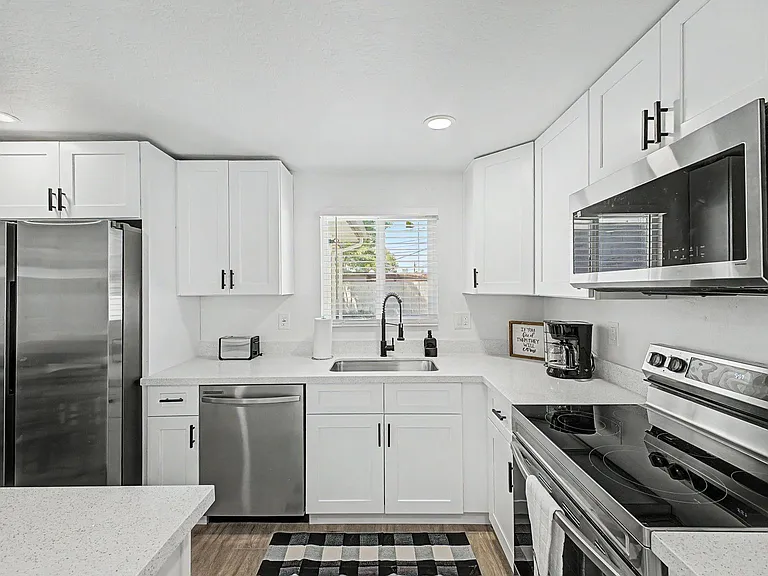 quartz-style counters, and stainless steel appliances plus a windowed sink.