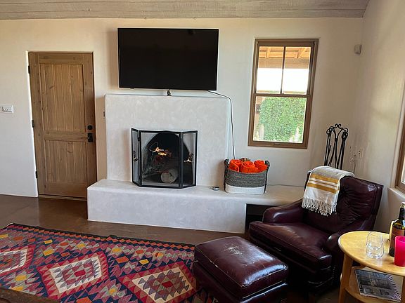 Inside the private and romantic main suite, complete with wood-burning fireplace, comfy sitting area and HD Smart TV