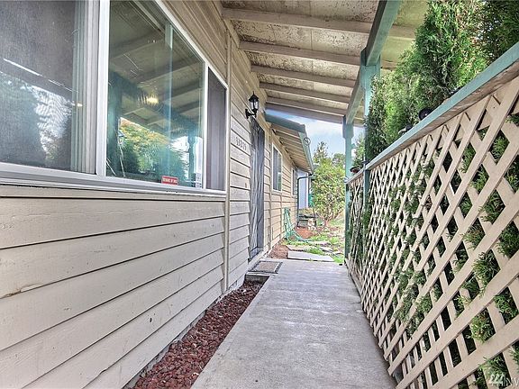 Welcoming living room with newer laminate flooring and cozy wood burning fireplace.