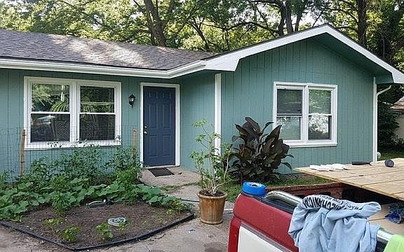 Front of house with long driveway and garden bed