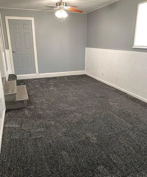 Family room (converted from garage), door leading to large storage room and back yard.