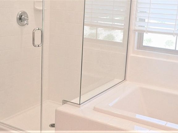 seperate shower and oversized bathtub with a view