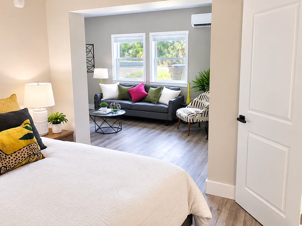 Bright and inviting open-concept apartment featuring a spacious bedroom, comfortable living area, and open kitchen that flow seamlessly together.