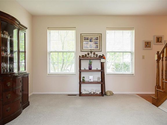 Carpeted living room with faux wood blinds.