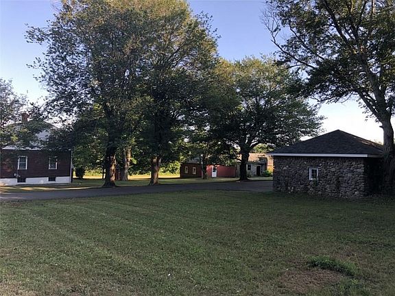 Right corner of property over looking the farm house, two car garage, and barn/storage building
