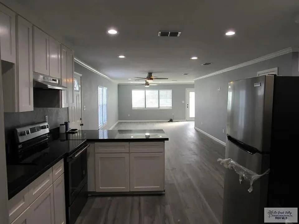 Back of kitchen looking forward to the front door through dining area and living room. - 718 Lozano St