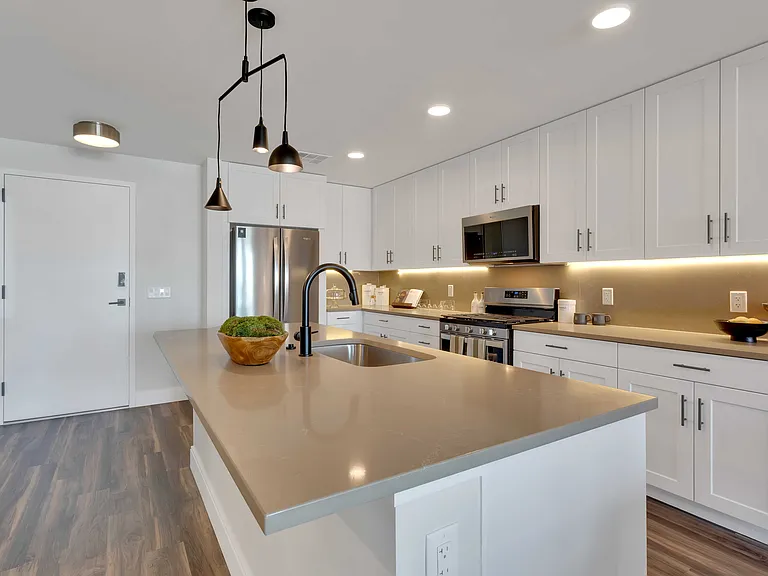 Modern kitchen with sleek cabinetry, stainless steel appliances, and stylish pendant lighting over a spacious island.