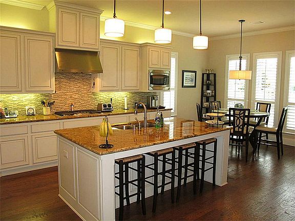 Phenomenal island kitchen boasts granite countertops & mosaic tile backsplash!