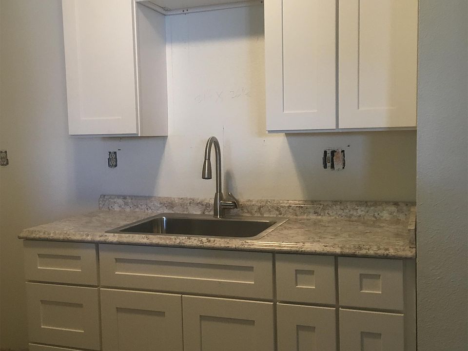 New kitchen with new cabinets, sink, faucet, stove and microwave.