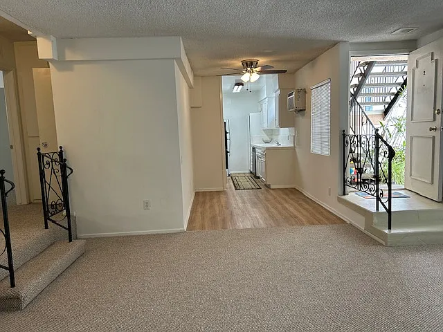 Another view from living room to dining room and kitchen beyond. Stairs on the left lead up to the two bedrooms