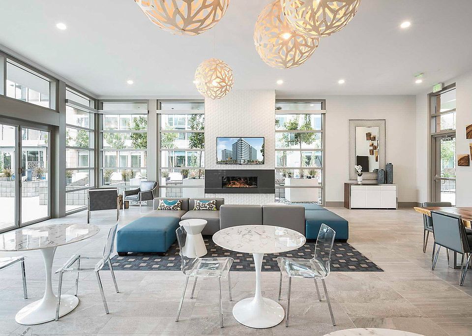 Club room with fireplace, dining table, lounge seating, and high ceilings.