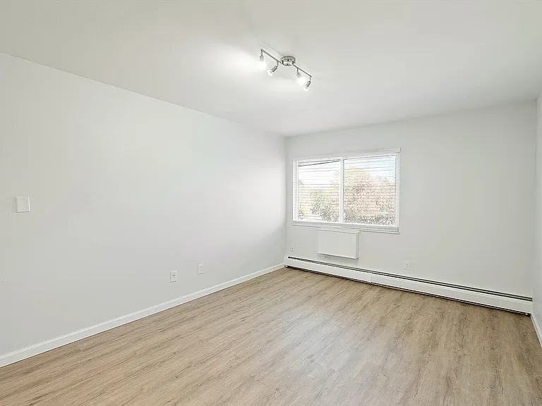 Bright and spacious room featuring elegant wood flooring and large windows for natural light.