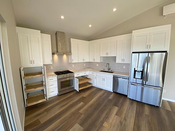 Gourmet kitchen with brand new fridge and diswwasher, Dacor gas cooktop and oven range, Victory hood and custom tile backsplash. High ceilings and more!