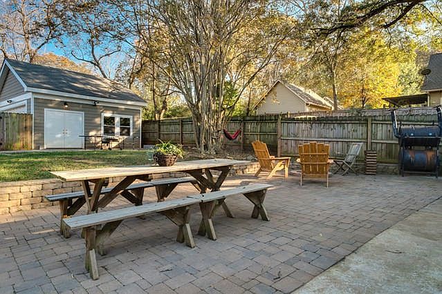 Fenced-in backyard with stone patio, fire pit, Ping Pong tab