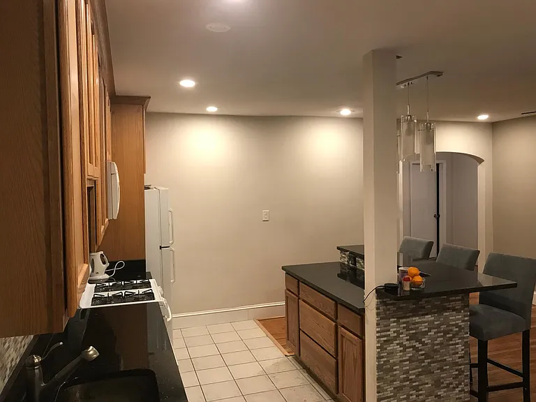 Open floor plan- furnished kitchen with cookware and silverware, furnished island with bar stools