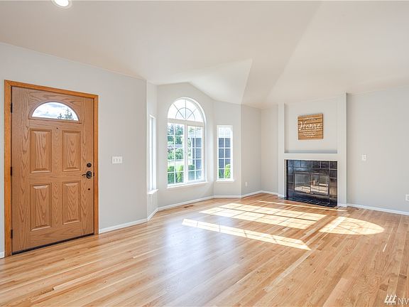 Bright living room with vaulted ceilings and gas fireplace. Hardwood floors are newly refinished.