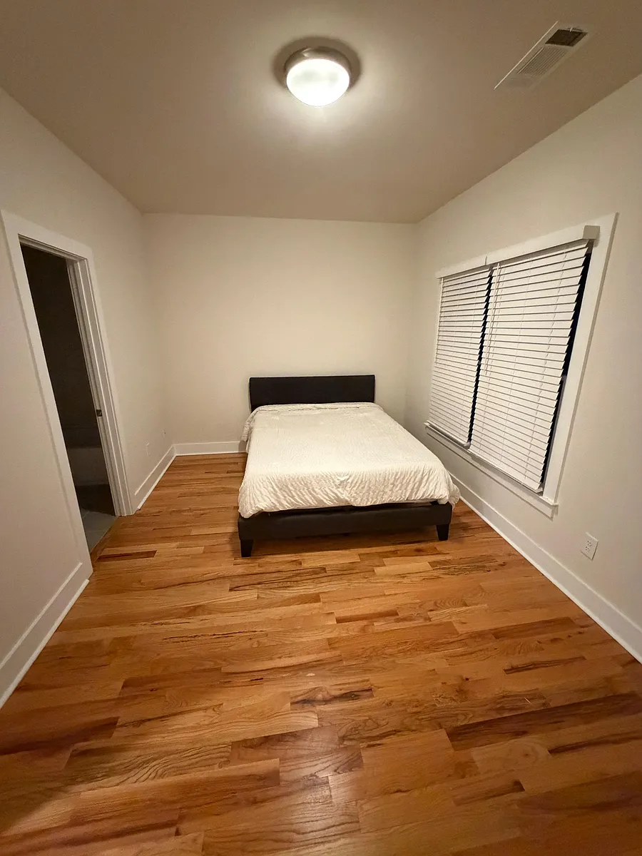 Private bedroom with hardwood floors, overhead lighting, and a large window with blinds for adjustable privacy. - Oakland Ter SW