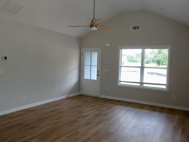 Living room as seen from dining room, vaulted ceilings & fan