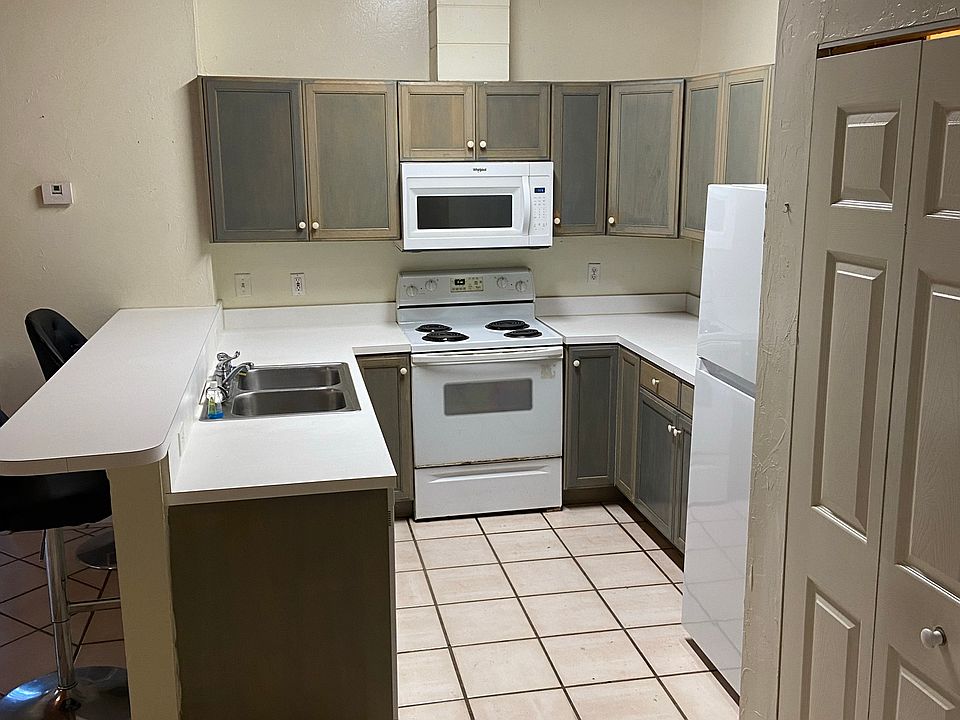 Full, spacious kitchen with dining bar and new appliances within 1 to 3 years; Closet in foreground houses new washer and dryer.