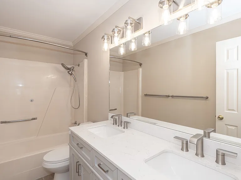 Bathroom with double vanity, modern lighting and fixtures.