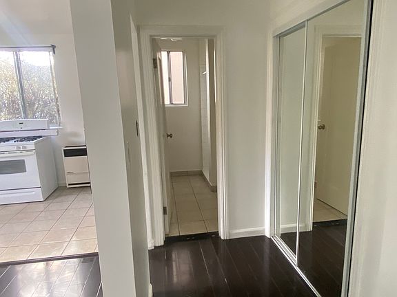 View from bed nook towards bathroom. Mirrored sliding door closet is to right in photo.
